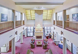 A large room with a red carpet and a white ceiling. Description generated by AI