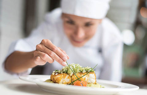 A woman in a kitchen preparing food. Description generated by AI