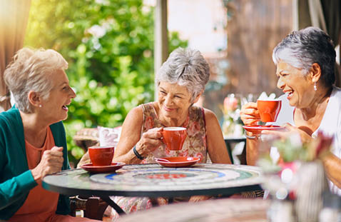 An older man is smiling while holding a deck of cards. AI generated content